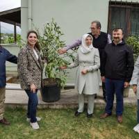 Dr. İsmail Çapçı ve Necati Büyükkaya, Arslan Ailesine günün anısına alınan Portakal  ağacını takdim ederken