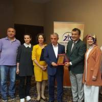 Hasan Uzunhasanoğlu Başkanlığındaki Akça Koca Kültür Platformu Yöneticileri, Körfez Kaymakamı Dr. Hasan Hüseyin Can’a teşekkür plaketini takdim ederken