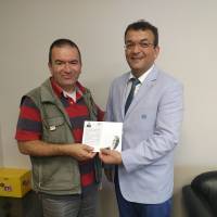Hasan Uzunhasanoğlu, Kocaeli Gazetesi Yöneticisi Erkan Ünal’a, Dr. Nuri Çağlar’a vefa toplantısı davetiyesini takdim ederken