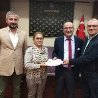 Coşkun Karakadılar, Saliha Aksoy, Dr. Oktay Taşolar birlikte, Dr. Zülfikar Özkan’a platformun hediyesini takdim ederken