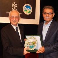 Eski Bakan Prof. Dr. Sami Güçlü, panelin sonunda Dr. Metin Eriş’e plaketini takdim ederken