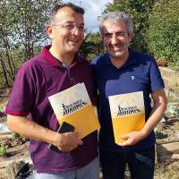 Hasan Uzunhasanoğlu ve Prof. Dr. Ali Demir toplantıda dağıtılan “Mesut Uğur’la Yürümek” kitabı