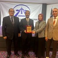 Ecz. Selçuk Arslan, Doç. Dr. Ayşe Zeynep Turan Civraz ve Dr. Yunus Özen birlikte Tolga Büyükkaya’ya Teşekkür plaketini takdim ederken