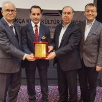 Ahsen Okyar, Dr. Alaattin Büyükkaya ve Hasan Uzunhasanoğlu birlikte Mümtaz Emeksiz’in plaketini Emex Hotel Genel Müdürüne takdim ederken