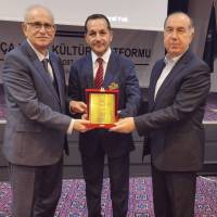 Ahsen Okyar ve Alaattin Büyükkaya Mümtaz Emeksiz adına plaketi takdim ederken