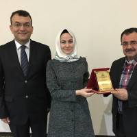 Hasan Uzunhasanoğlu ve Necati Pilavcı birlikte Merve Yılmaz’a plaketini takdim ederken