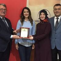 Abdullah Köktürk, Dr. Ayşe Zeynep Turan ve Hasan Uzunhasanoğlu, İrem Nur Gümüş’e plaket takdim ederken