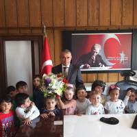 Körfez Uçan Balon Gündüz Bakım Evi öğrencileri Dr. Hasan Hüseyin Can’a çiçek takdim ederken