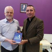 Dr. Yunus Özen, Mavi Kocaeli Gazetesi Sorumlu Yazı İşleri Müdürü Mustafa Elbi’ye davetiye ve Dr. Alaattin Büyükkaya’ya ait “Yalnız Yürümeyeceksin” kitabını takdim ederken